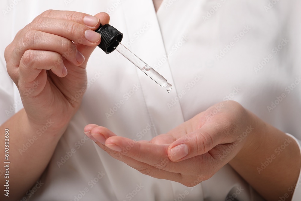 Woman applying cosmetic serum onto hand, closeup Woman applying cosmetic serum onto hand, closeup