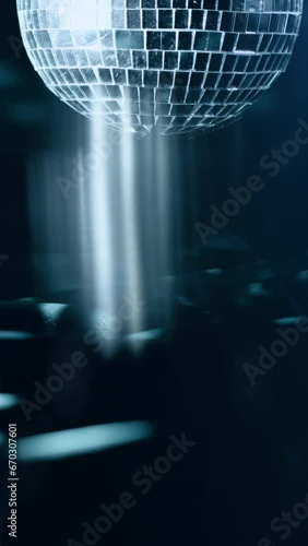 Mirror disco ball rotating, reflecting rays of light. 4k Dance Party Glitter Background. Vertical