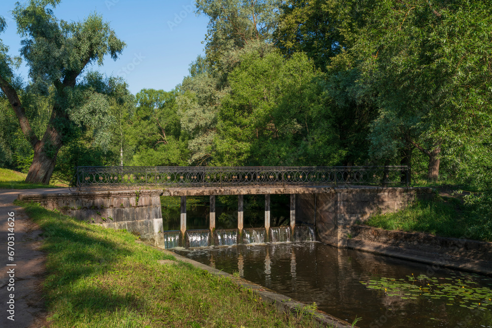 Slavyanka River and the Black Bridge in the Pavlovsk Palace and Park Complex on a sunny summer day, Pavlovsk, Saint Petersburg, Russia Slavyanka River and the Black Bridge in the Pavlovsk Palace and Park Complex on a sunny summer day, Pavlovsk, Saint Petersburg, Russia