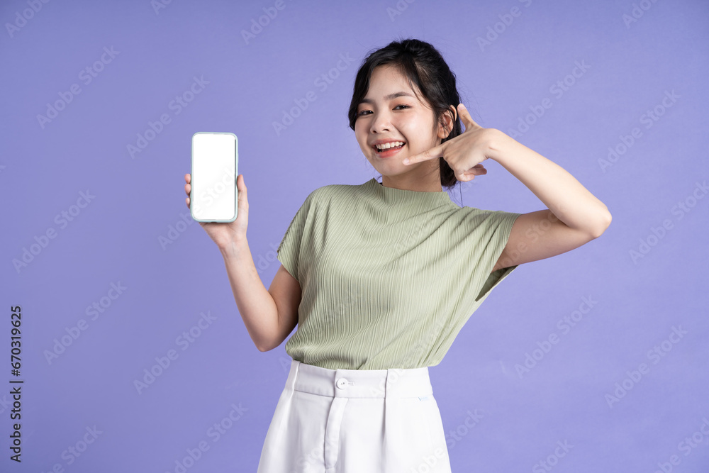 Portrait of beautiful asian woman using smartphone on purple background Portrait of beautiful asian woman using smartphone on purple background