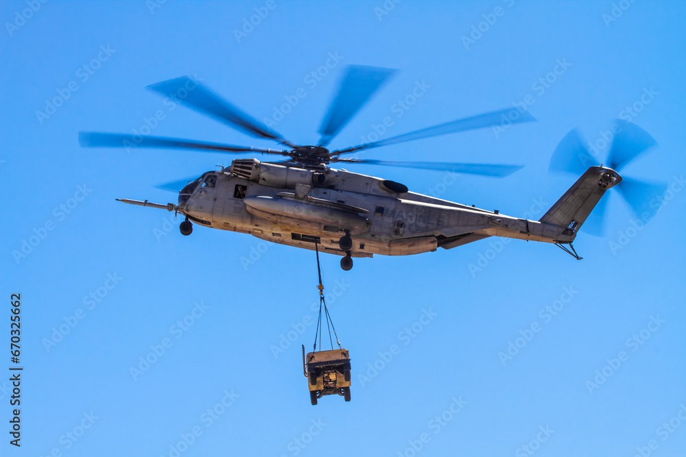Sikorsky CH-53 Sea Stallion Military helicopter in formation and carrying cargo humvee Sikorsky CH-53 Sea Stallion Military helicopter in formation and carrying cargo humvee