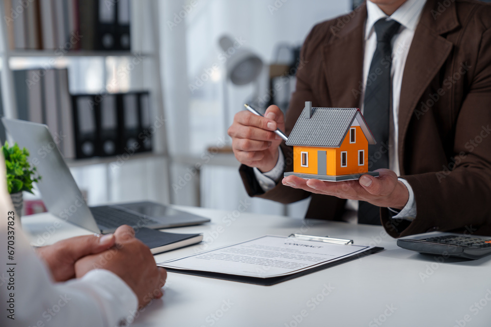 Fototapeta premium Real estate company to buy houses and land are delivering keys and houses to customers after agreeing to make a home purchase agreement and make a loan agreement. Discussion with a real estate agent