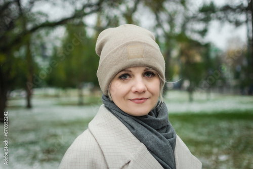 a young woman in a light hat is walking on the street. street portrait. advertising of warm clothes. cold season