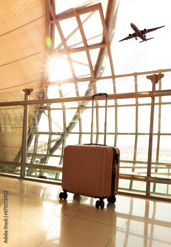 Travel concept with pink luggage as hat in the airport terminal waiting area, summer vacation concept, traveling and enjoying concept