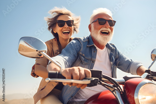 Close up view of a senior couple riding a motorbike on a sunny summer day on open road © sam
