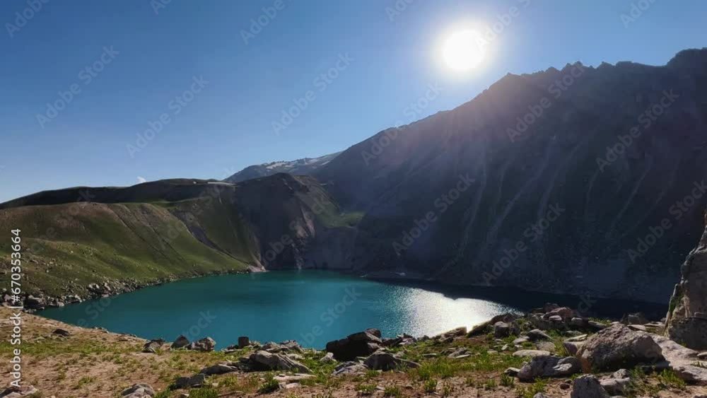 Turquoise mountain lake on the high plateau of Angren. View from the top of the mountain to the large lake Arashan at an altitude of 3365 m above sea level. Blue sky over the lake. Uzbekistan 4K Turquoise mountain lake on the high plateau of Angren. View from the top of the mountain to the large lake Arashan at an altitude of 3365 m above sea level. Blue sky over the lake. Uzbekistan 4K