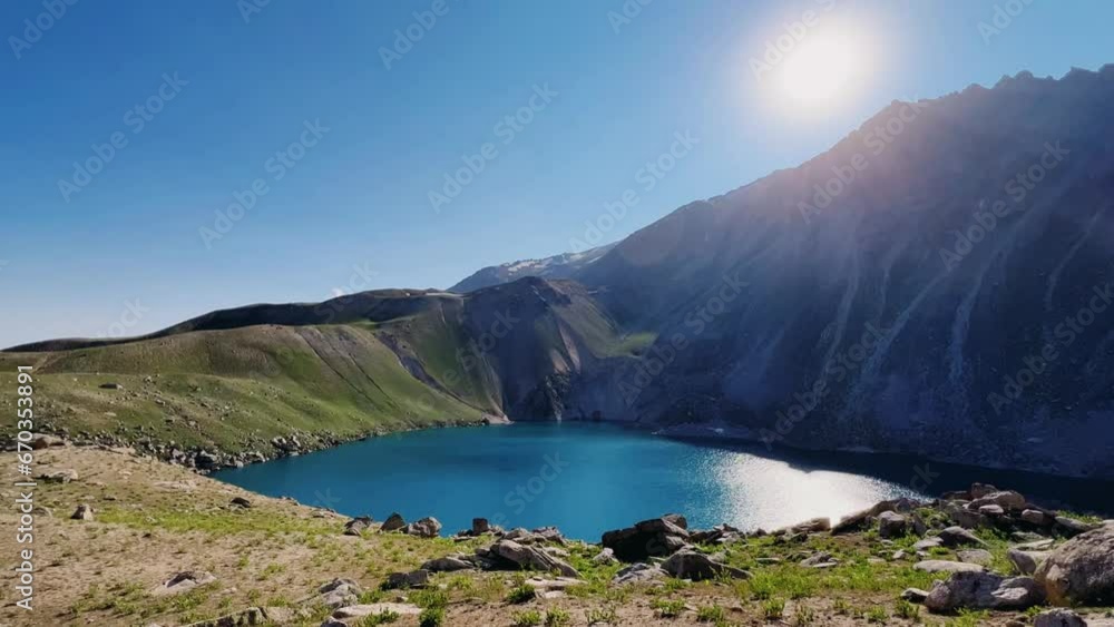 Turquoise mountain lake on the high plateau of Angren. View from the top of the mountain to the large lake Arashan at an altitude of 3365 m above sea level. Blue sky over the lake. Uzbekistan 4K Turquoise mountain lake on the high plateau of Angren. View from the top of the mountain to the large lake Arashan at an altitude of 3365 m above sea level. Blue sky over the lake. Uzbekistan 4K