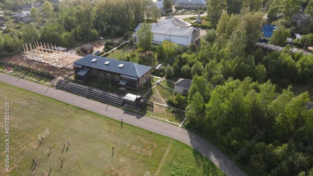 Big green stadium with football players among the trees Big green stadium with football players among the trees