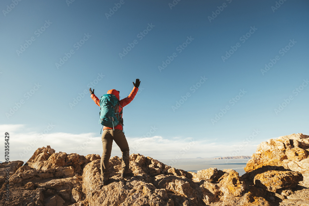 Woman hiker enjoy the view on mountain top cliff edge at lakeside