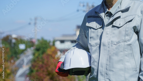 ヘルメットを持つ作業服の男性｜建設業・製造業などのイメージ photo