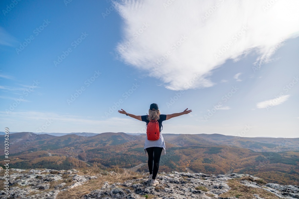 woman backpack on mountain peak looking in beautiful mountain valley in autumn. Landscape with sporty young woman, blu sky in fall. Hiking. Nature woman backpack on mountain peak looking in beautiful mountain valley in autumn. Landscape with sporty young woman, blu sky in fall. Hiking. Nature