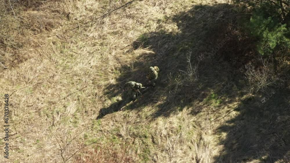 Men Dressed As US American Soldiers Of USA Infantry Of World War II carry mortar for battle In dry grass. Aerial view elevated shot, Men Dressed As US American Soldiers Of USA Infantry Of World War II carry mortar for battle In dry grass. Aerial view elevated shot,