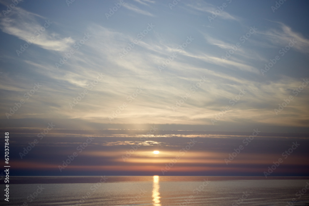 Amazing scenery with sky coloured by the sunset reflecting the calm sea water, selective focus