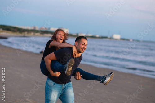 Happy couple, love and travel at the beach having fun on date, quality time and romance at sunset. Funny woman and man, laughing and walking together by the ocean on honeymoon during summer