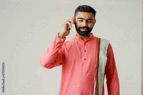 "Isolated Indian farmer holding a phone, symbolizing modern agricultural practices in India