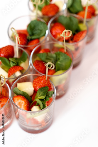 portions of fruit in glasses, strawberries and pineapple, buffet table, waiting for guests