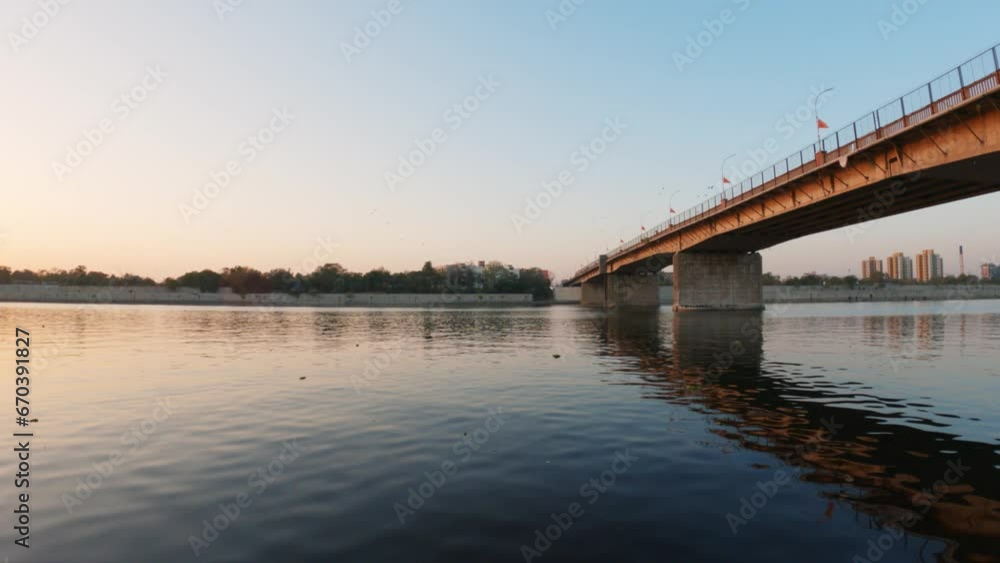4K video of Beautiful Sunset view with its reflection of bridge in water at River front, Ahmedabad, India. Cityscape with buildings at riverside. Ahmedabad city of Gujarat. 4K video of Beautiful Sunset view with its reflection of bridge in water at River front, Ahmedabad, India. Cityscape with buildings at riverside. Ahmedabad city of Gujarat.