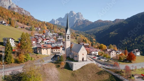 4k drone flight point of view (Ultra High Definition) of San Lorenzo Catholic church. Exciting autumn cityscape of Selva di Cadore village, Province of Belluno, Italy. Traveling concept background.. photo