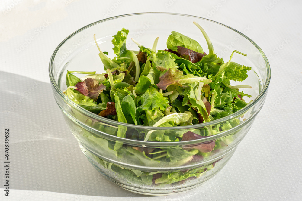 Green salad, fresh in a transparent glass bowl