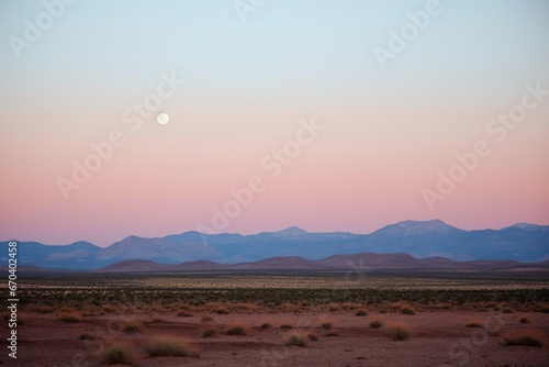 full moon rising over desert landscape