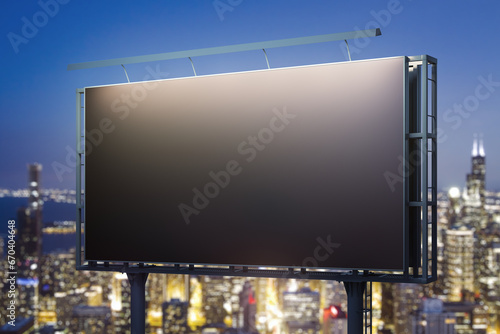 Blank black horizontal billboard on city buildings background at night, perspective view. Mockup, advertising concept