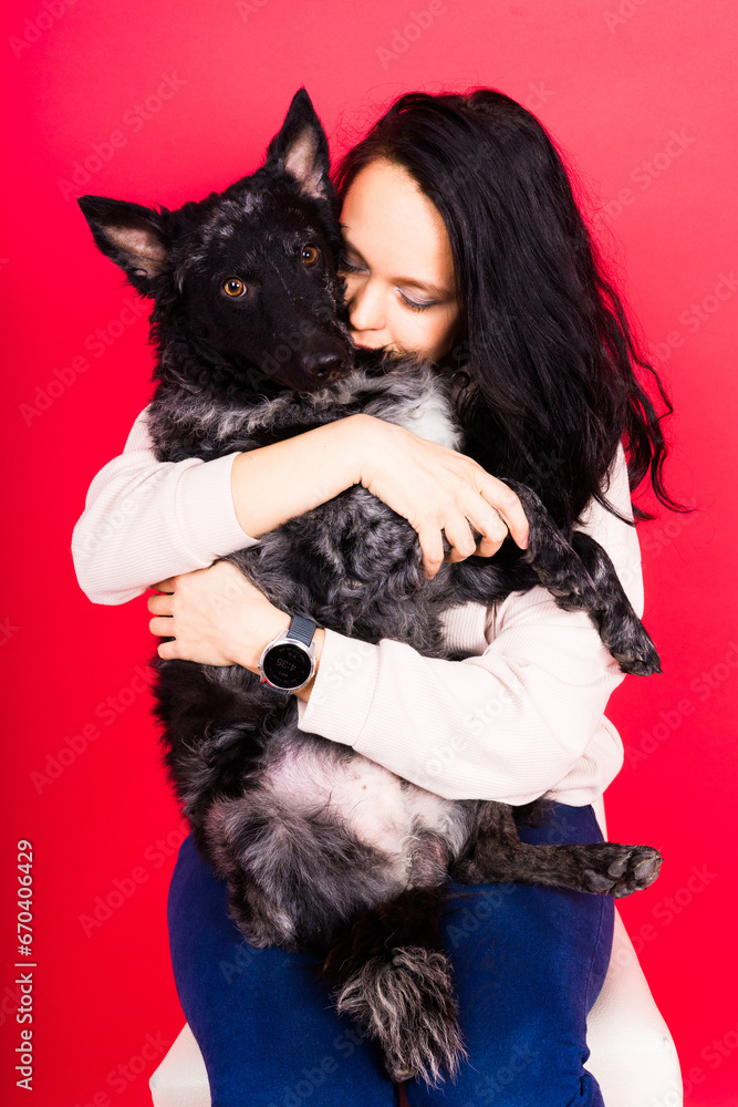 Happy brunette lady in casual wear hugging mudi pet dog, studio background. Happy brunette lady in casual wear hugging mudi pet dog, studio background.