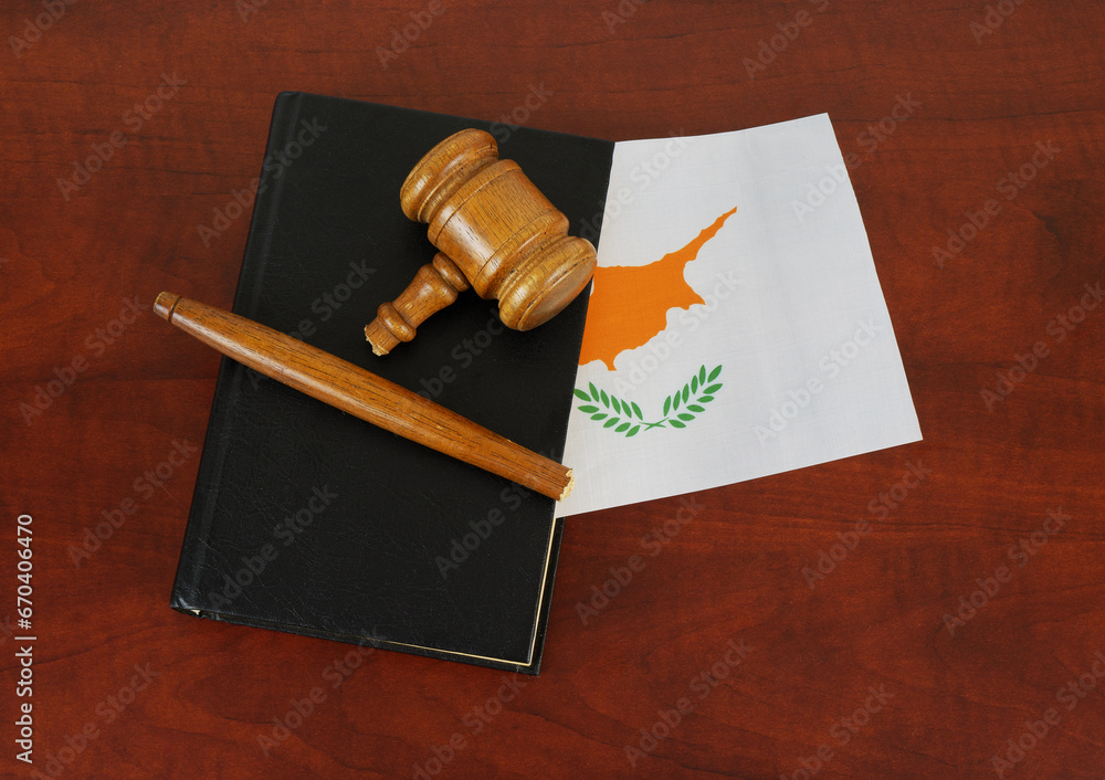 Broken judge gavel and legal book with  flag of Cyprus. Laws and court problems in Cyprus