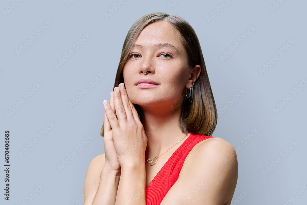 Young woman with natural makeup, with trendy nose piercing jewelry on gray background Young woman with natural makeup, with trendy nose piercing jewelry on gray background