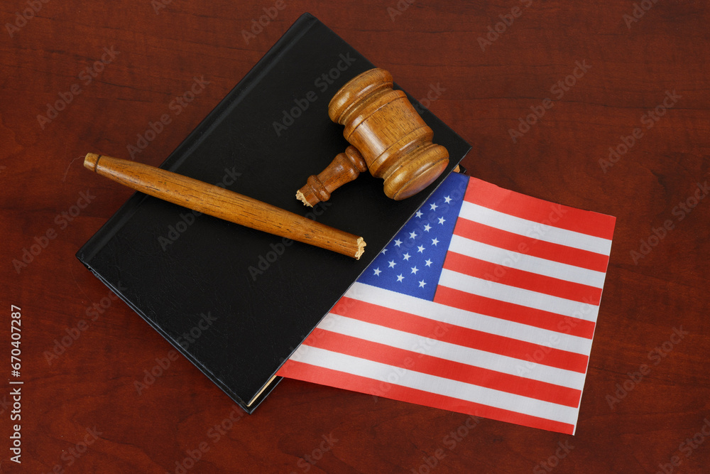 Black legal book with US flag and broken wooden judge gavel. Concept of lawlessness and injustice.