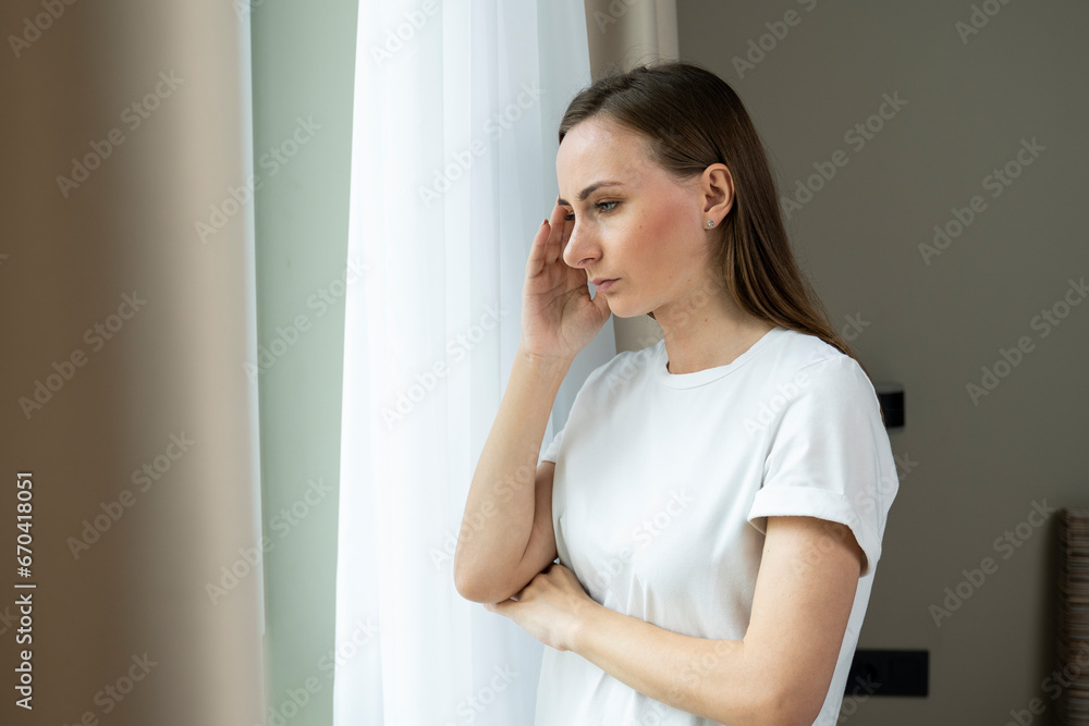 A worried, frustrated young woman feeling depressed and lonely, suffering from a headache after an emotional trauma, in need of psychological help A worried, frustrated young woman feeling depressed and lonely, suffering from a headache after an emotional trauma, in need of psychological help