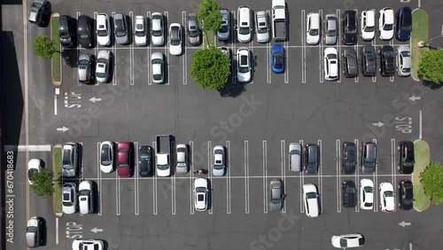 A busy parking lot in daytime - straight down rising aerial view photo