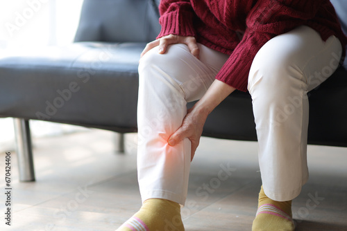 Senior woman with osteoarthritis has leg pain. photo