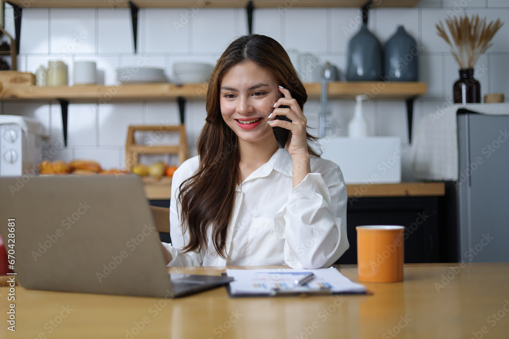 Woman working with laptop at home using mobile phone reading texts and sending text messages. Woman working with laptop at home using mobile phone reading texts and sending text messages.