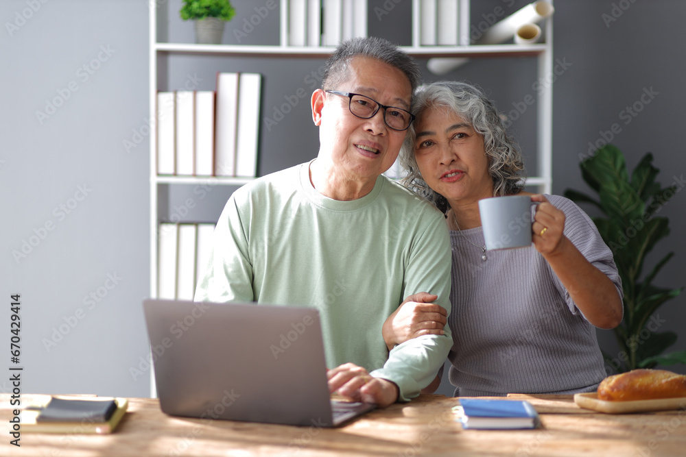 Happy senior couple in retirement at home. Men and women are using laptop in the home office. Happy senior couple in retirement at home. Men and women are using laptop in the home office.