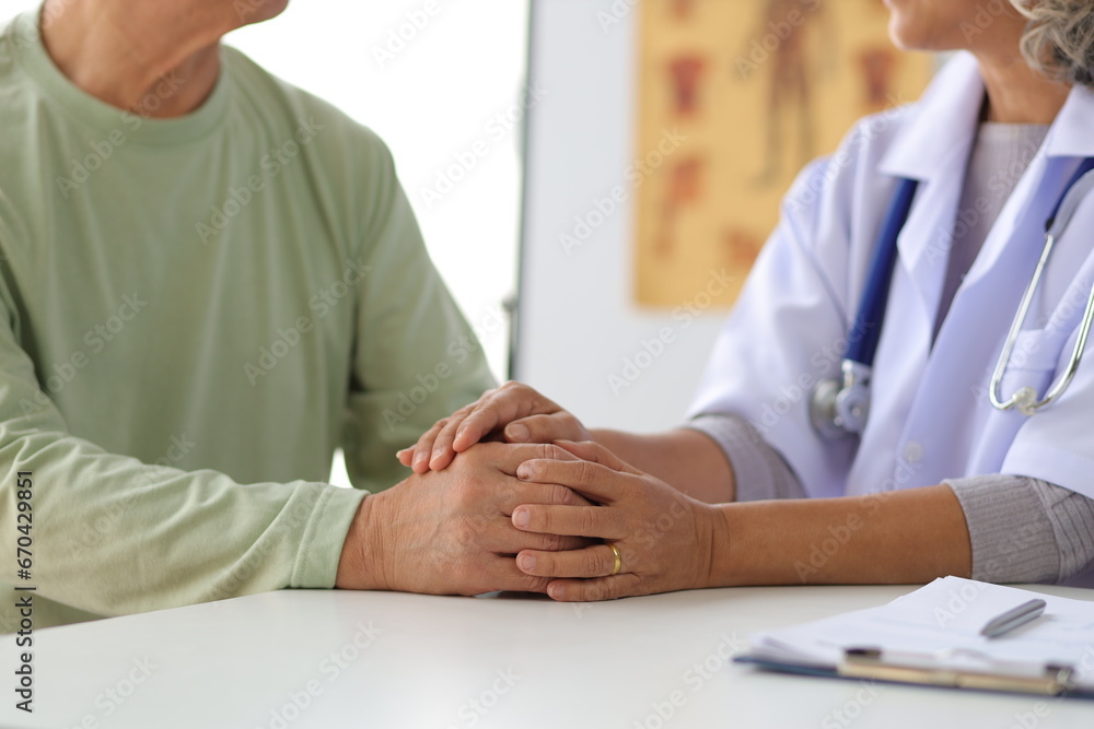 Senior health care concept. Doctor with patient in medical office. Retired man sits in a hospital examination room while discussing his health with a doctor. Senior health care concept. Doctor with patient in medical office. Retired man sits in a hospital examination room while discussing his health with a doctor.