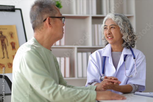 Senior health care concept. Doctor with patient in medical office. Retired man sits in a hospital examination room while discussing his health with a doctor.