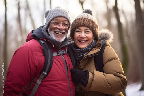 Middle age mixed race couple enjoying outdoors activity in winter forest