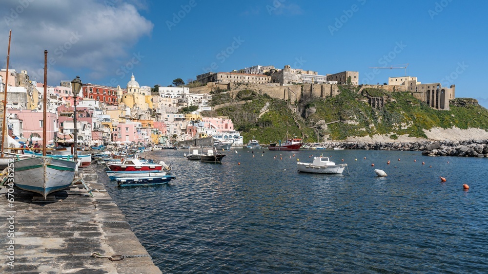 Corricella port in Procida, Italy with a variety of colorful fishing boats moored in the harbor