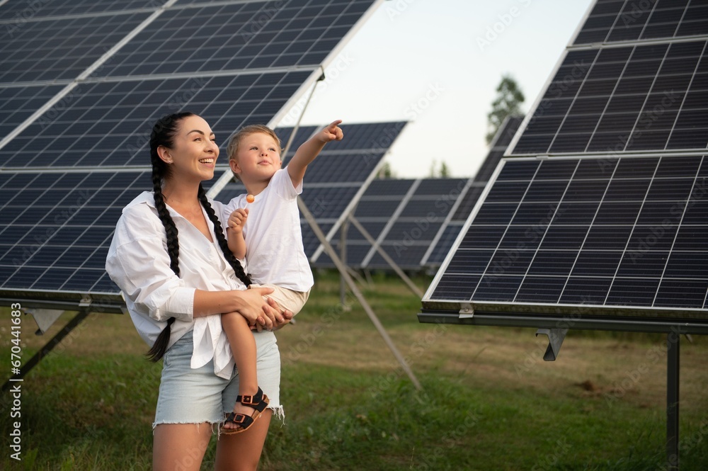Mother with her little son by solar panels