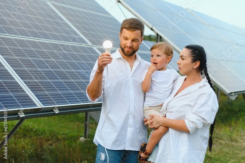 The concept of renewable energy. Young happy family near solar panels