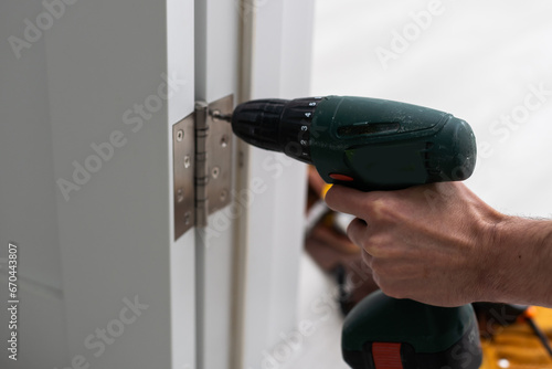 A handyman repair the door lock in the room. The concept repair yourself. Selective focus