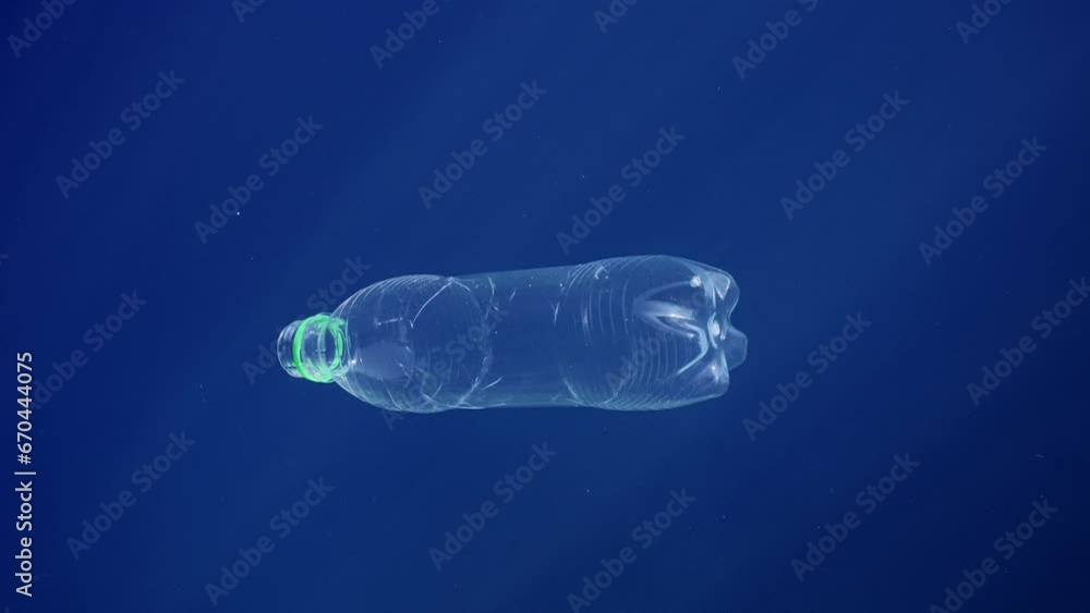 Transparent plastic bottle slowly sinks in blue water of Mediterranean Sea under bright sunrays, Close-up, Slow motion. Plastic pollution of Ocean Transparent plastic bottle slowly sinks in blue water of Mediterranean Sea under bright sunrays, Close-up, Slow motion. Plastic pollution of Ocean