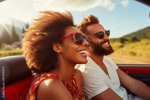 Happy smiling young couple driving vintage cabriolet car, going on the fun road trip together