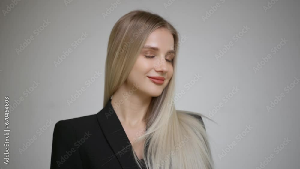 Luxurious long blonde hair in motion. Gray background. Luxurious long blonde hair in motion. Gray background.