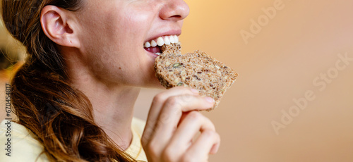 Canvastavla Young woman eating healthy multigrain bread close up.