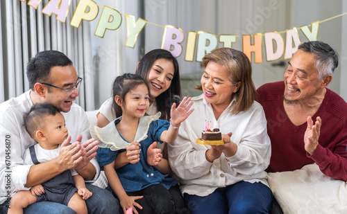 Portrait of happy love asian big family father and mother with asian baby and little girl happy birthday, party, celebration, cake, surprise, grandfather with grandmother smiling together.Family party