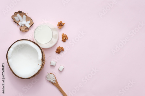 Glass of coconut milk and coconut close up on a pastel purple background with space for text. Coconut vegan milk non dairy or Dairy free milk concept. Healthy vegan food.