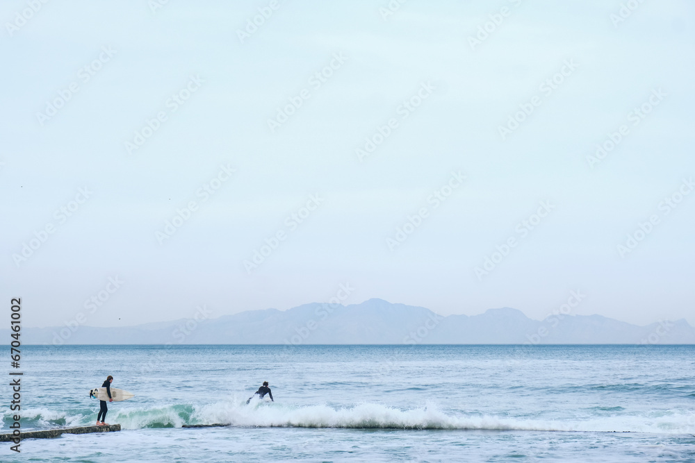 Surfer enters ocean for a surf session.