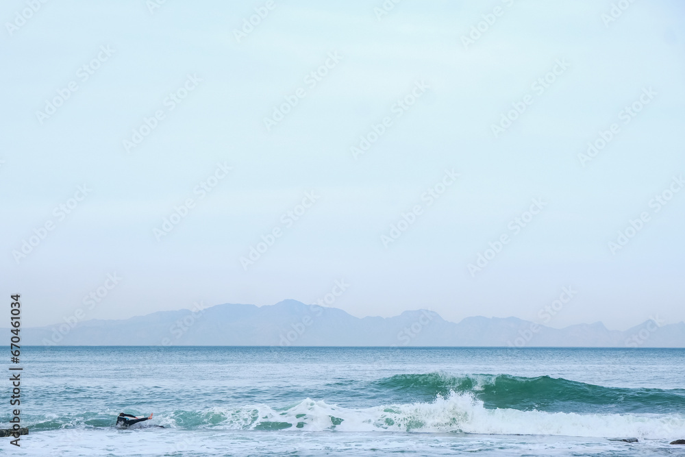 Surfer falls with wave 