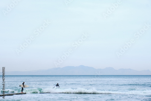 Surfer enters ocean for a surf session.